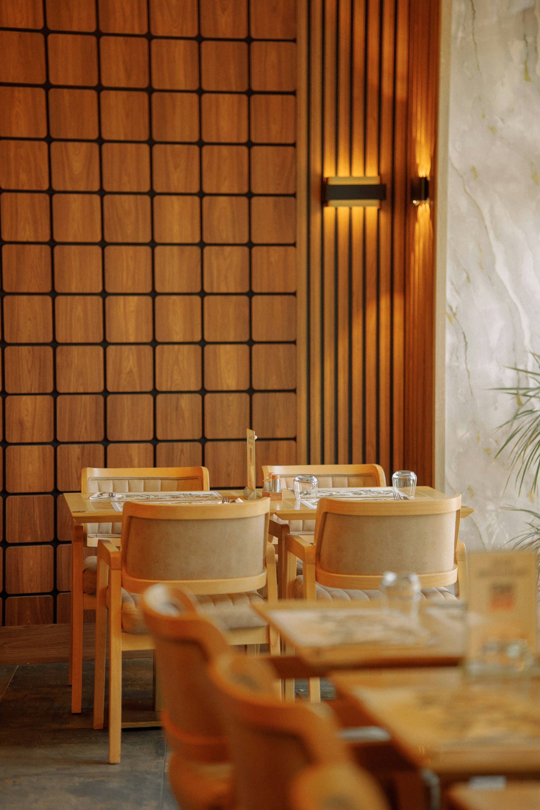 Warm restaurant interior with wood panels and intimate dining settings