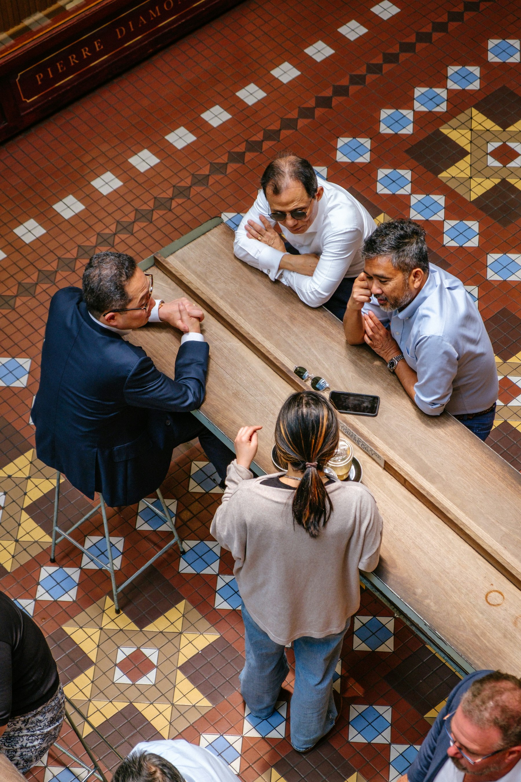 People gathered around a wooden table in discussion